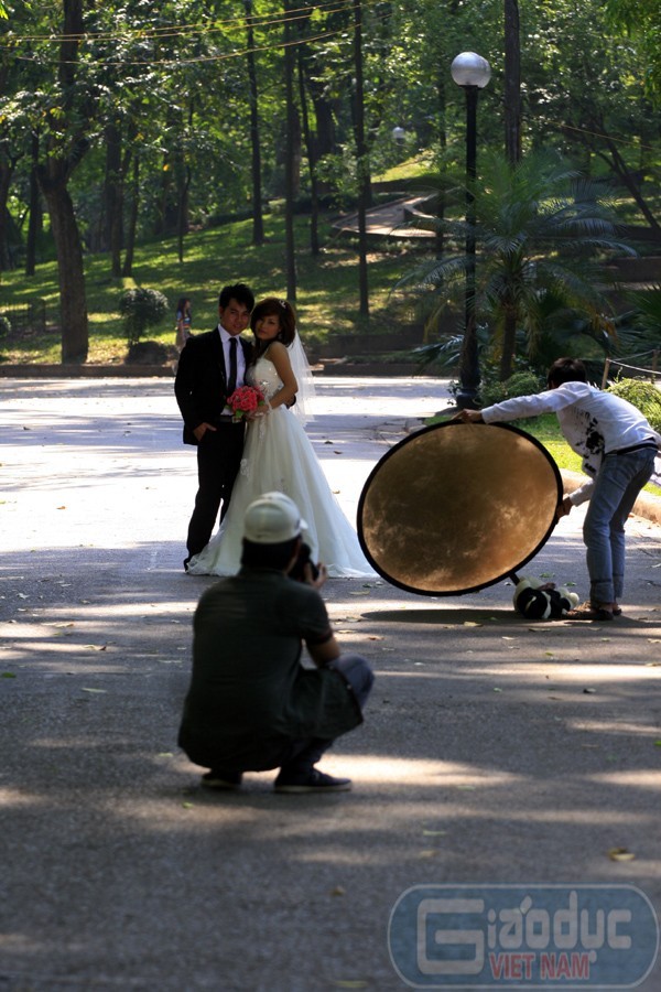 Những cặp uyên ương tranh thủ bóng râm trong công viên để chụp ảnh cưới vì nắng gắt